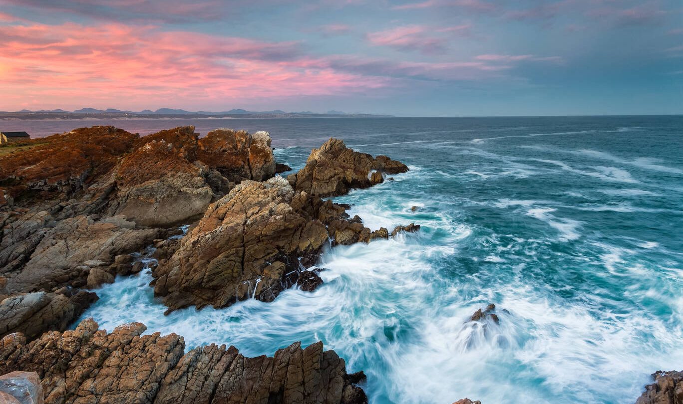 Wide angle landscape image of rock formations and the indian ocean along the Garden Route coast of South Africa